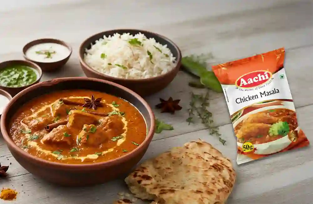 Aachi Chicken Masala pack displayed with flavorful chicken curry, highlighting its rich spice blend.